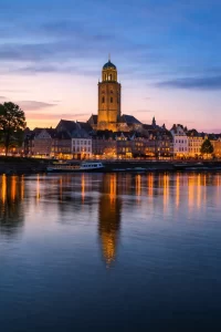 Sfeervolle avond in Deventer met historische gevels en warme reflecties op het water.